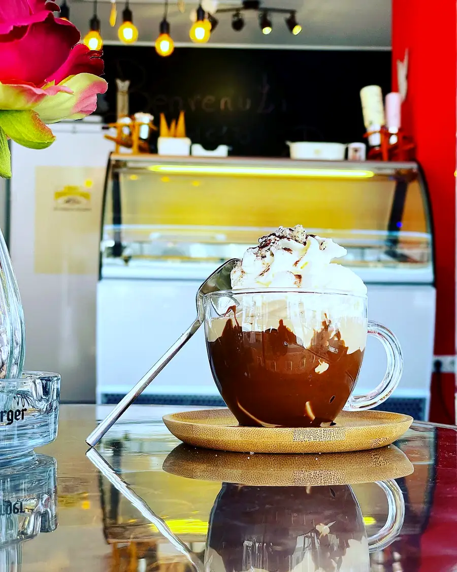 Heiße Schokolade mit Schlagobers vor der Eisvitrine