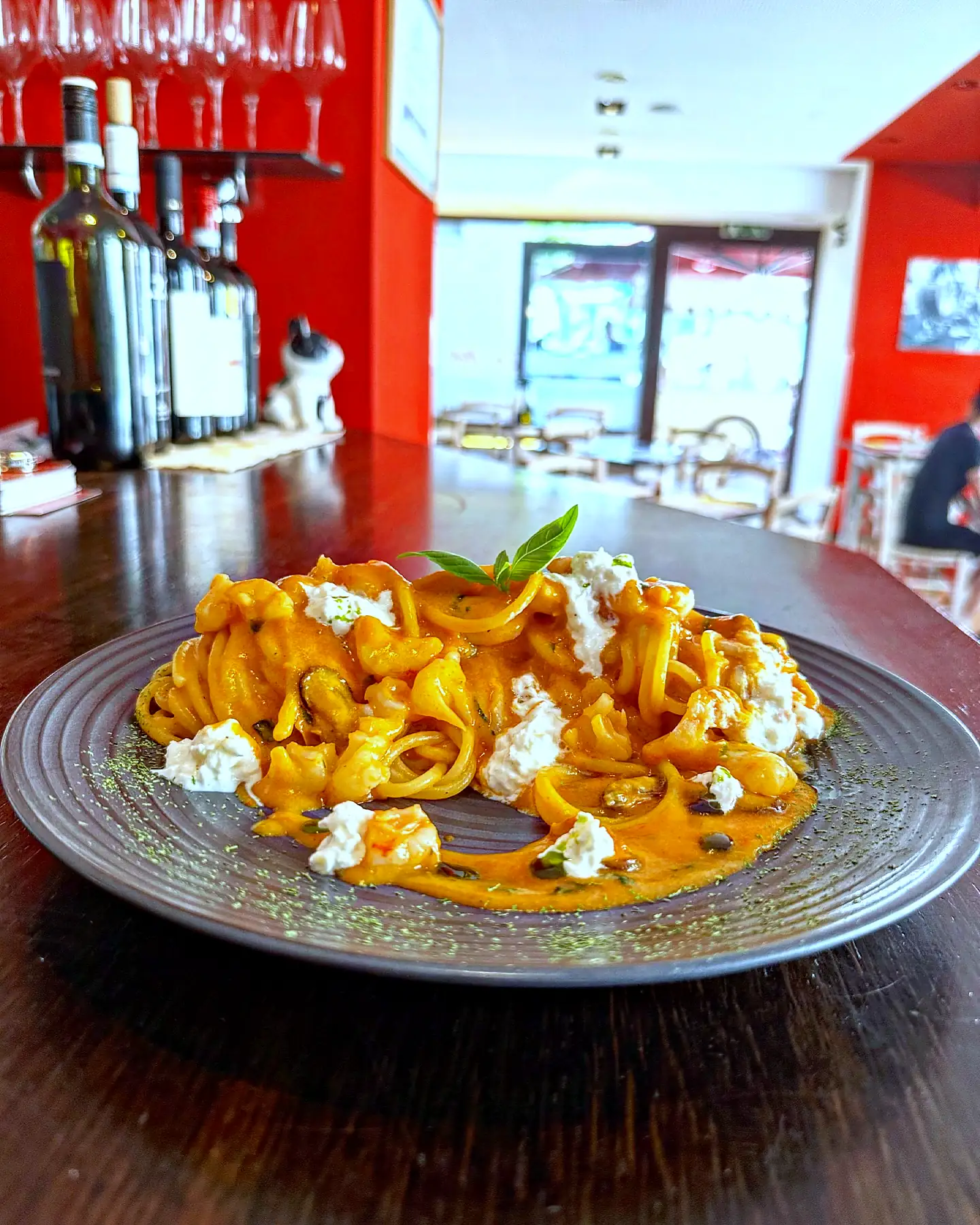 Pasta mit Ricotta auf der Theke, dahinter der Gastraum mit roten Wänden
