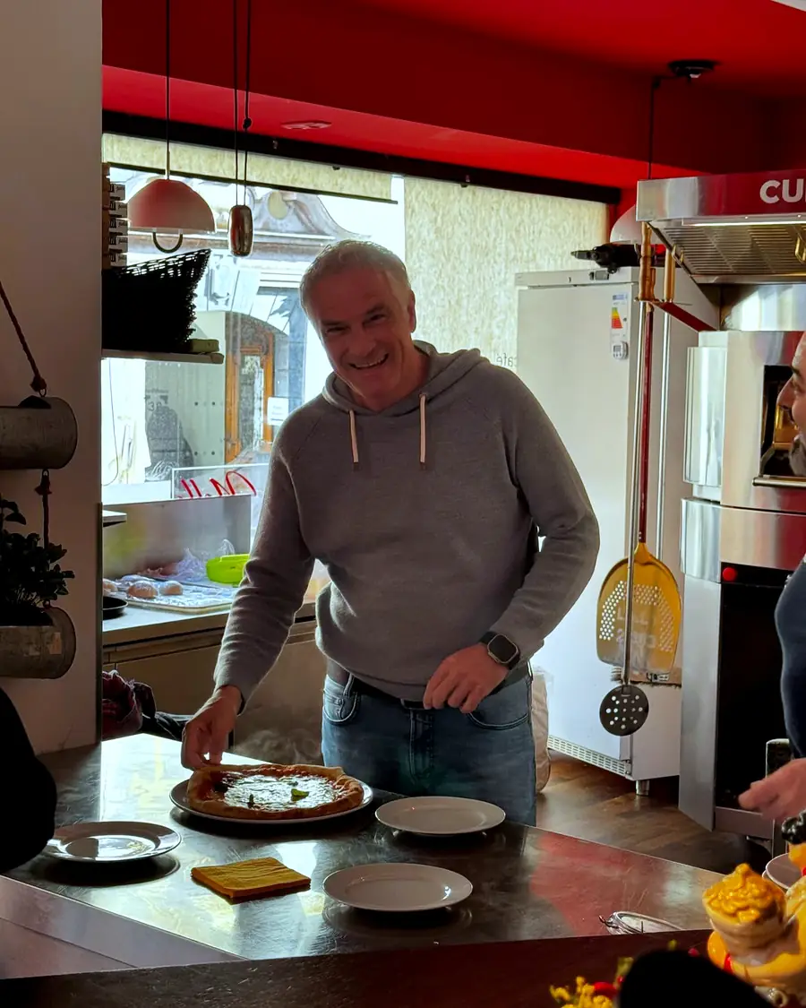 Inhaber Nello an der Theke, vor ihm eine frische Pizza