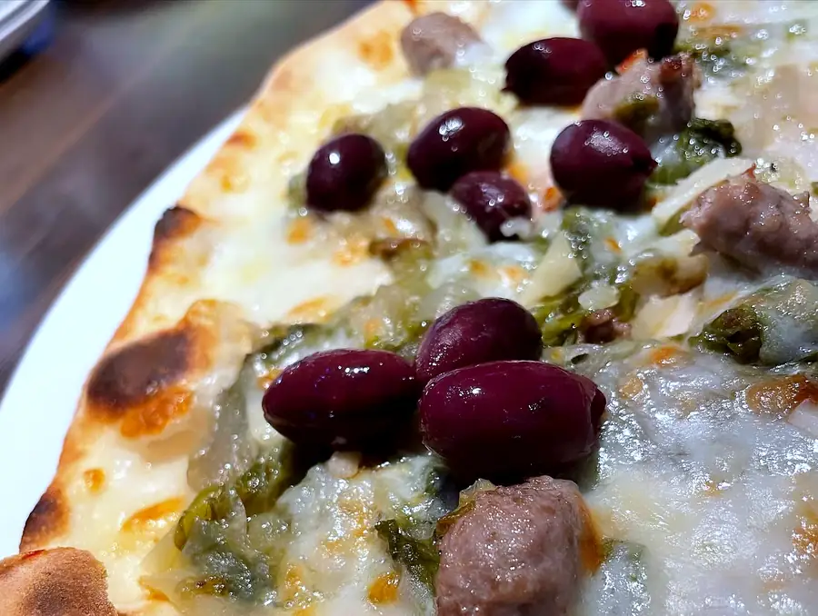 Pizza mit Oliven, Salsiccia und Friarielli, knuspriger Rand